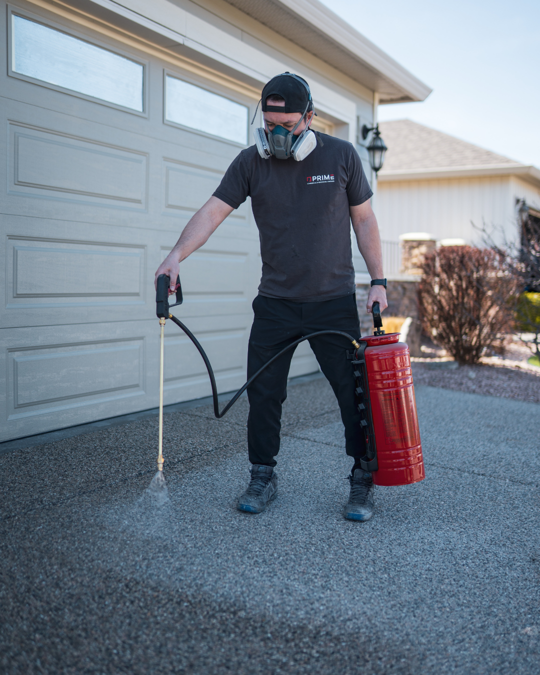 Professional applying concrete sealer to an exposed aggregate driveway in Kelowna