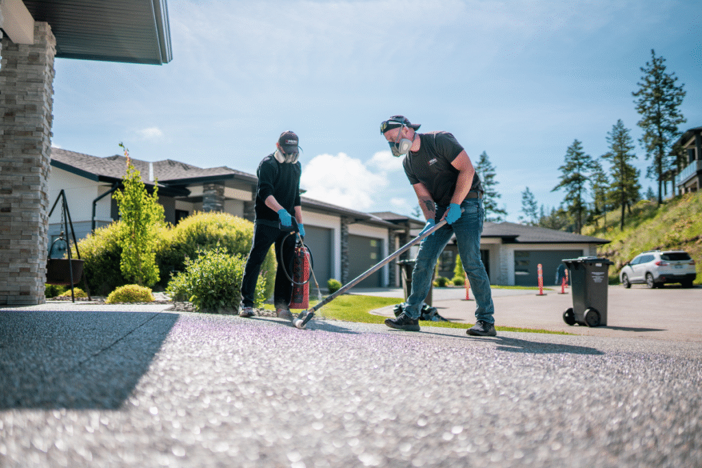 Prime Concrete Coatings technicians applying sealer to driveway in Kelowna